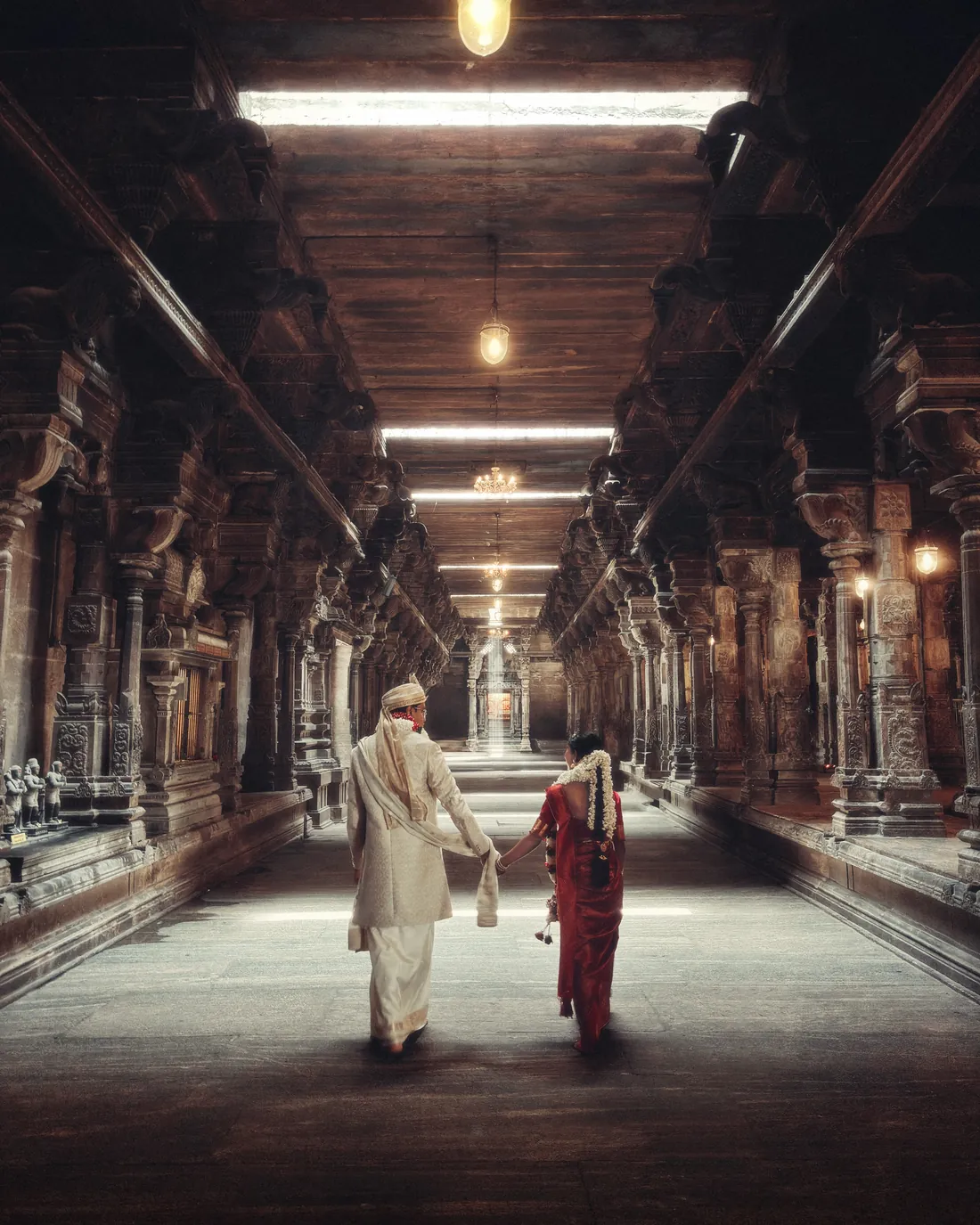 Seyon and Ashi walking down a pillared temple corridor