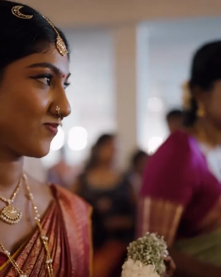 A bride smiling to herself, jasmine in her hair
