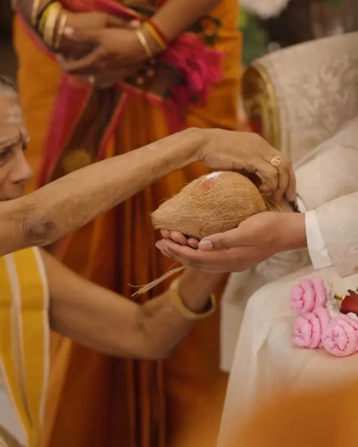 Elders’ hands passing a coconut during the blessings